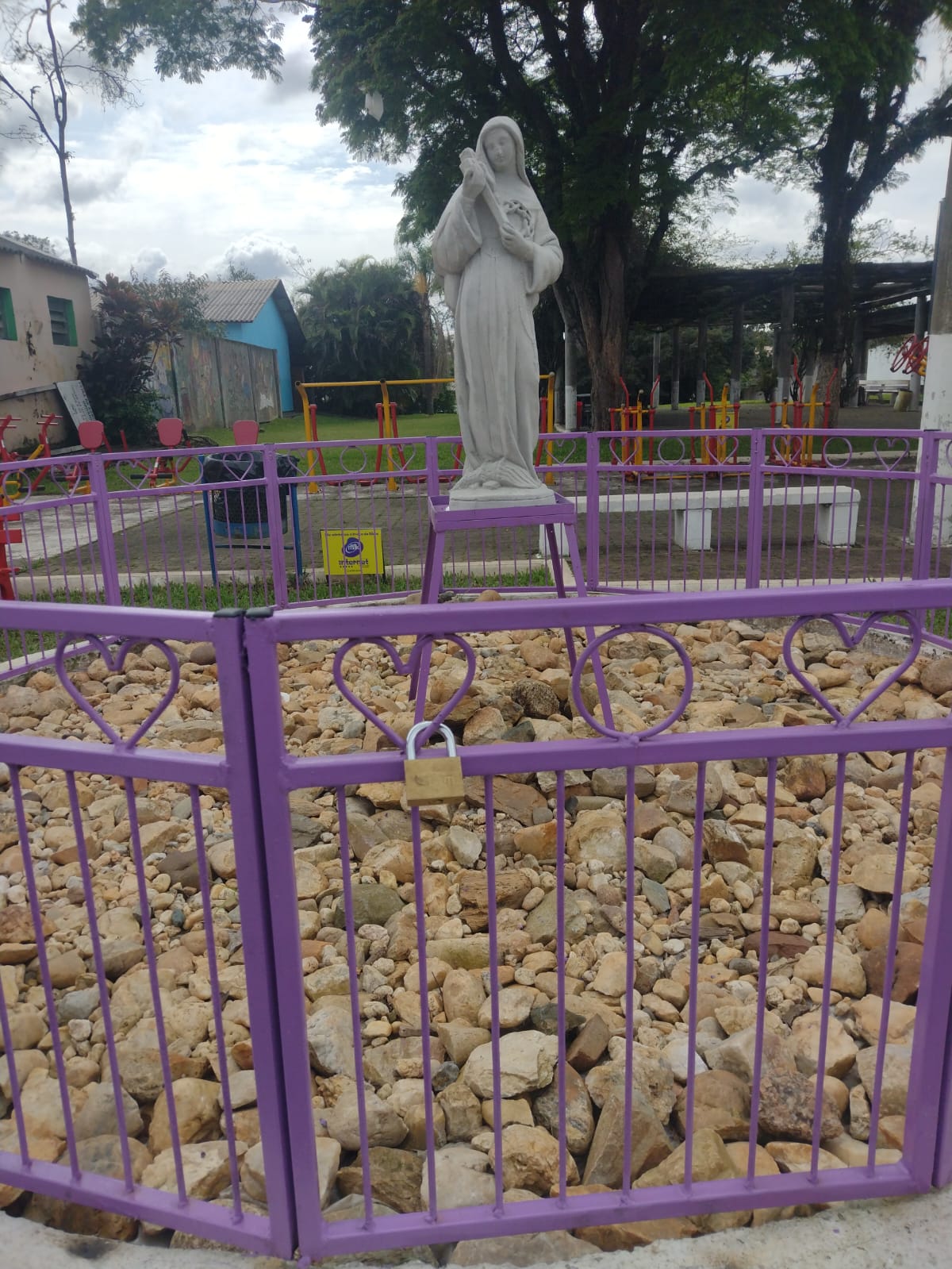 Grade roxa em formato de corações que cerca a imagem de Santa Rita de Cássia na Praça da Bíblia